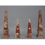A pair of marble obelisks, rouge griotte on a stepped square plinth,