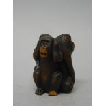 A Japanese wood okimono of the three wise monkeys, 20th century, carved seated back to back, (a.