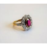 A gold, ruby and diamond oval cluster ring,