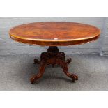 A Victorian figured walnut loo table, the oval snaptop on four carved downswept supports,