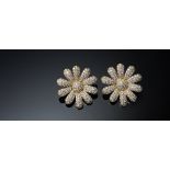 A pair of gold and diamond set earclips, each designed as a flowerhead,