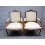 A pair of Louis XV style walnut framed open armchairs,