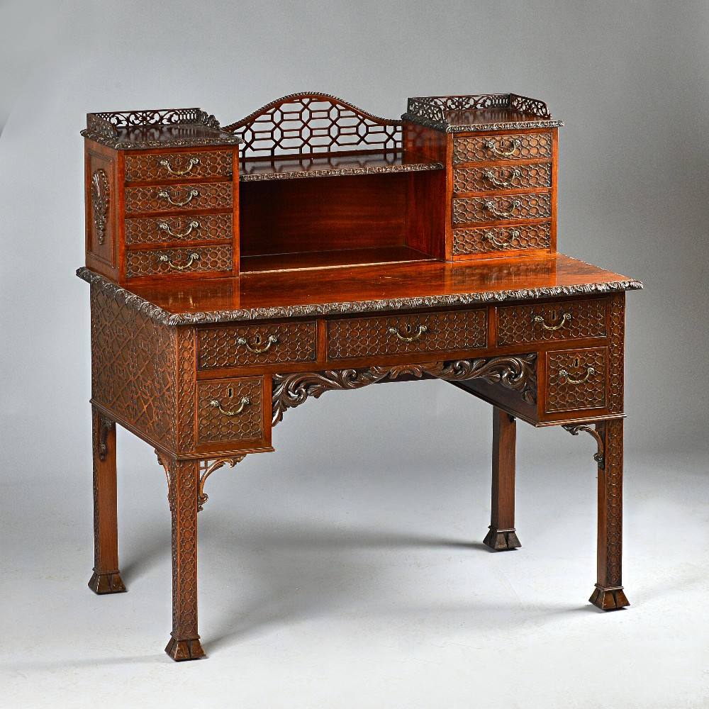 A carved mahogany desk after a design by Chippendale, the whole with blind fretwork decoration,