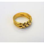 A gold keeper ring, in an interwoven design, detailed 18 C, ring size M, weight 7.1 gms.