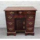 A mid-18th century mahogany kneehole writing desk with eight drawers about the kneehole cupboard,