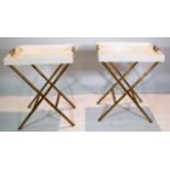A pair of white lacquer butler's trays on folding gilt brass bamboo bases, 63cm wide x 75cm high.