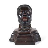 An early 20th century hardwood carved figural inkwell, pre-1918, modelled as a Nubian man,