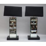A pair of modern glass mounted table lamps, each on a leather rectangular base, with shades,