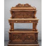 A 19th century Continental carved walnut three tier buffet, with pair of drawers over cupboards,