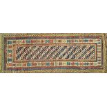 An antique Genje runner, Caucasian, the banded field with an ivory medallion border, 280cm x 108cm.