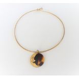 A gold, diamond set and tortoiseshell pendant, of circular form,