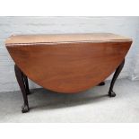 A mid-18th century Irish mahogany drop flap dining table on shell capped cabriole supports on ball