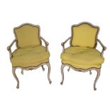 A pair of Louis XV style parcel gilt fauteuils on cabriole supports.