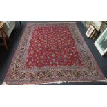 A Kashan carpet, Persian, the madder field with an allover floral sprays design,