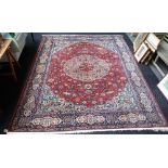 A Tabriz carpet, Persian, the madder field with a bold roundel of palmetts and animals,