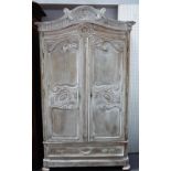 A 19th century limed oak armoire, with pair of shaped double panel doors, over single drawer,