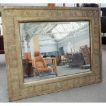 A large 19th century Arts and Crafts wall mirror with wriggle work and stylized leaf moulded frame,