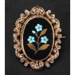 A gold and onyx mourning brooch, the oval onyx with floral mosaic decoration,