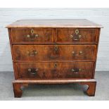 A George I inlaid figured walnut chest of two short and two long graduated drawers on bracket feet,