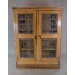 An art Nouveau style pine two door display cabinet, 120cm wide x 160cm high.