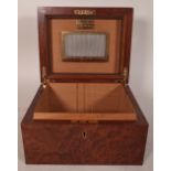 An Amboyna wood humidor, circa. 1960, with domed hinged lid over a rectangular body. 24.5cm wide.