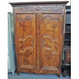 An 18th century Continental fruitwood and elm armoire, with pair of doors with three shaped panels,