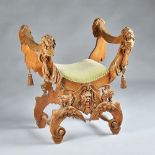 An Italian Renaissance style extensively carved X frame stool with cherub,
