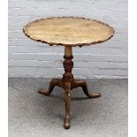 A George III mahogany tripod occasional table, with pie crust snap top on spiral fluted column,