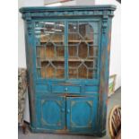 A 19th century Irish blue painted pine corner cupboard with pair of astragal glazed doors over