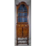 A Queen Anne mahogany arch top display cabinet with single drawer over cupboard doors on bun feet,