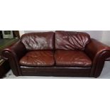A 20th century hardwood farmed leather armchair on bun feet, and sofa.