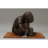 A modern bronze depicting a young boy tying his shoe-laces, signed 'Oliver' to the cast (13.