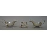 A pair of silver sauceboats, each having wavy rims and raised on three pad feet,