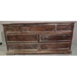 A 20th century Indian hardwood low chest, with three short and four long drawers on bracket feet,