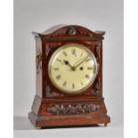 A Victorian mahogany cased mantel clock with shaped top and carved foliate embellishments,