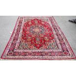 A Khorassan carpet, deep red field with central blue and white medallion and similar spandrels,