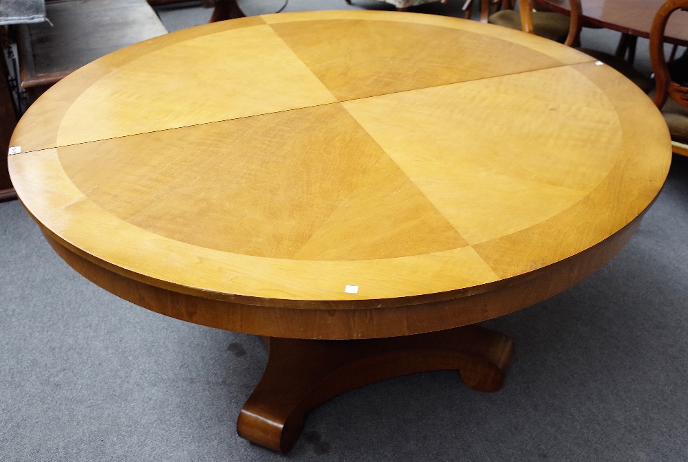 An Empire style walnut extending dining table, on turned column and four downswept supports,