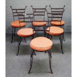 A set of fourteen wrought iron gardens chairs, with splayed ladder backs and supports,