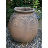 A large terracotta oil jar, of bulbous tapering form, with banded body, 110cm high.