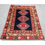 A Shirvan rug, Caucasian, plain indigo field, with three single madder medallions, three borders,