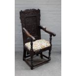 A Charles I carved oak panel back open armchair, on baluster turned supports,