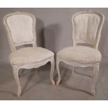 A pair of Louis XV style white painted dining chairs on cabriole supports, (2).
