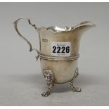 An Edwardian silver cream jug, with double scroll handle and wavy rim,