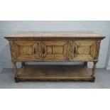 A 17th century style carved oak dresser base, with three recessed panel doors, on turned supports,