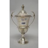 A silver twin handled trophy cup and cover, presentation inscribed,
