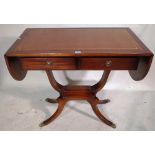 A George III style mahogany sofa table with two drawers and tan leather inset top,