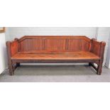 A Victorian Gothic Revival oak pew with tongue and groove back and panel sides on canted block