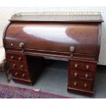 A 19th century mahogany roll top desk with fitted interior and six pedestal drawers,