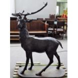 A cast metal figure of a standing stag on an oval base, 102cm wide x 145cm high.