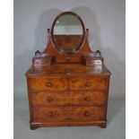 A Victorian walnut dressing chest with three long graduated drawers and oval mirrored back,